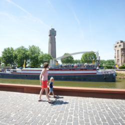 Vakantieganger langs de ijzer met op de achtergrond de oude en nieuwe vredestoren