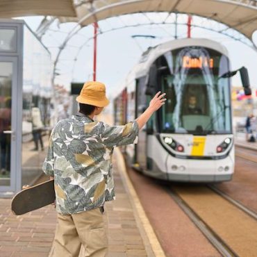 Vakantieganger aan de halte van de kusttram in Nieuwpoort-Stad